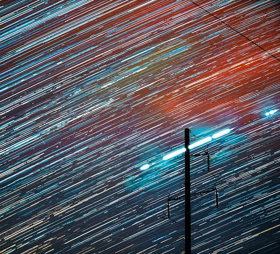 Star trails above utility lines representing ML arteka's structured cloud modernization.