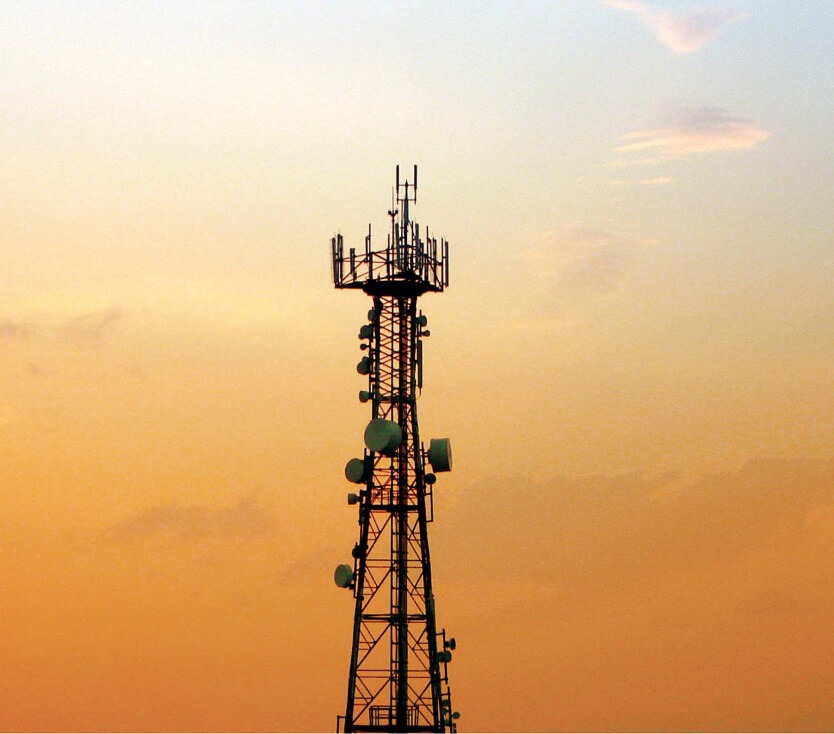 Cell tower at sunset representing ML arteka resilient telecom engineering