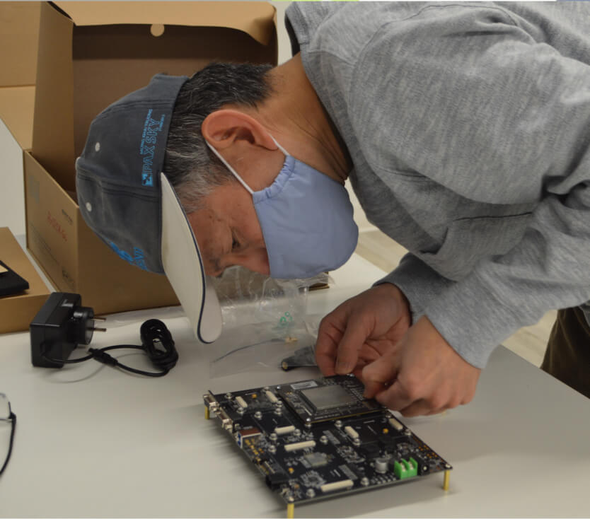 ML arteka practitioner assembling electronics, representing hands-on partner engineering.