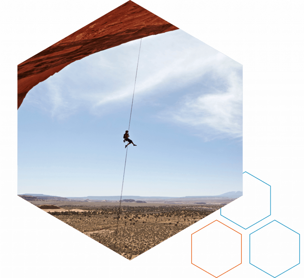 Climber under a rock overhang, representing ML arteka execution in regulated industries.